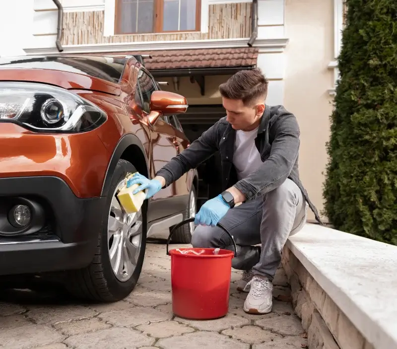 Lavage auto à domicile Ham-sur-Meuse : professionnel intervenant sur un véhicule